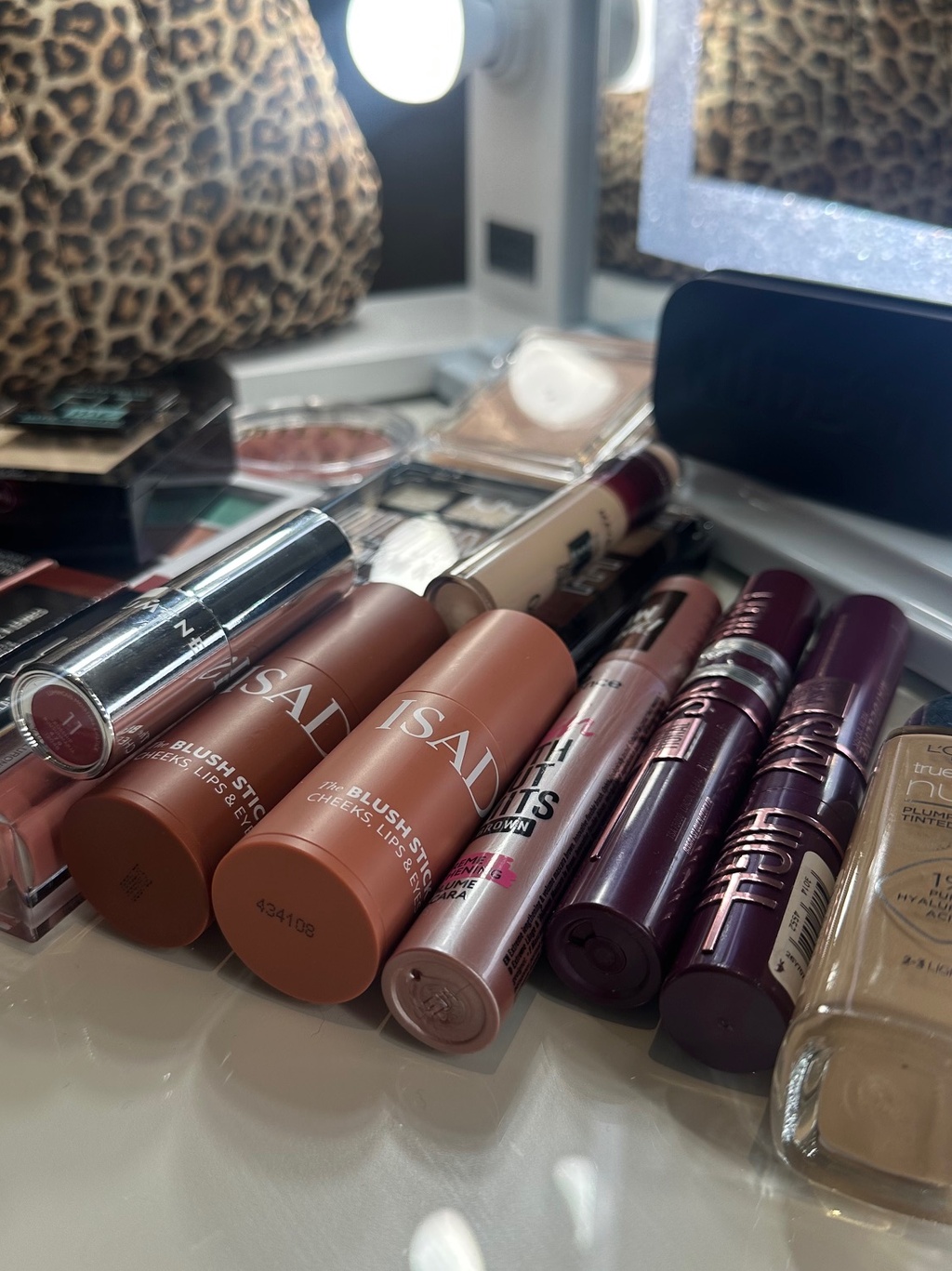 Kuvassa lähikuvassa meikkipöydällä kasa ja valikoima erilaisia meikkituotteita.