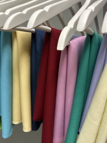 Kuvassa värianalyysikankaita henkareissa vierekkäin.